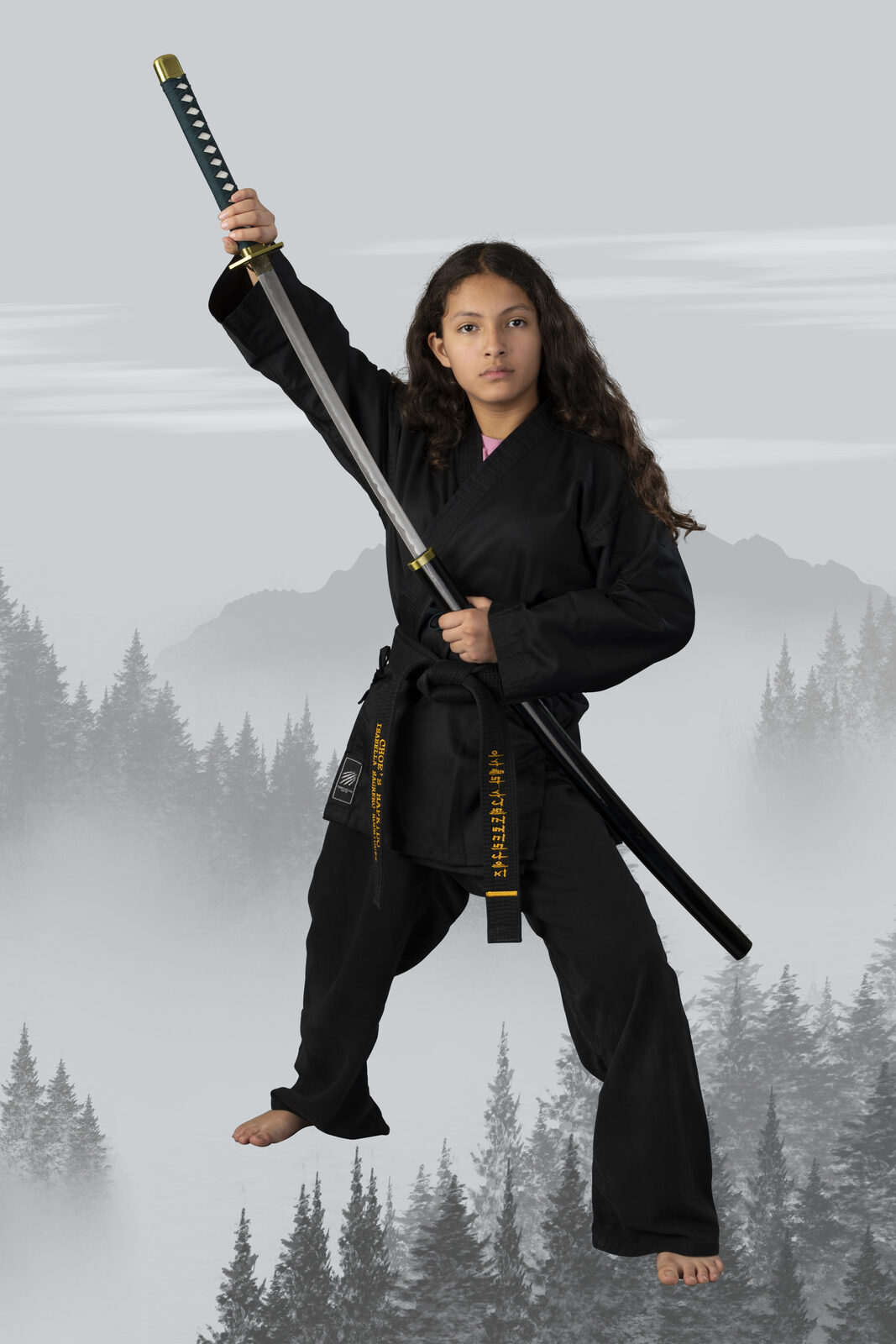 Advanced student posing with a sword in a forest composite